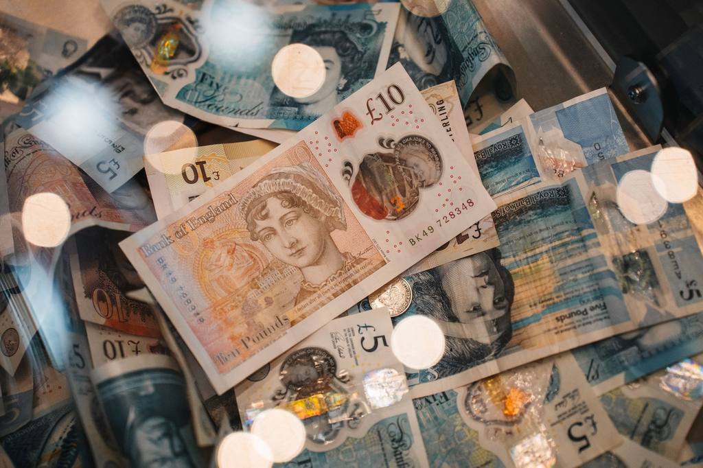 British five and ten pound banknotes with coins in close-up